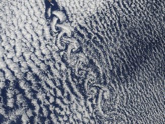 Scientific illustration: A satellite photo of clouds swirling into spirals.