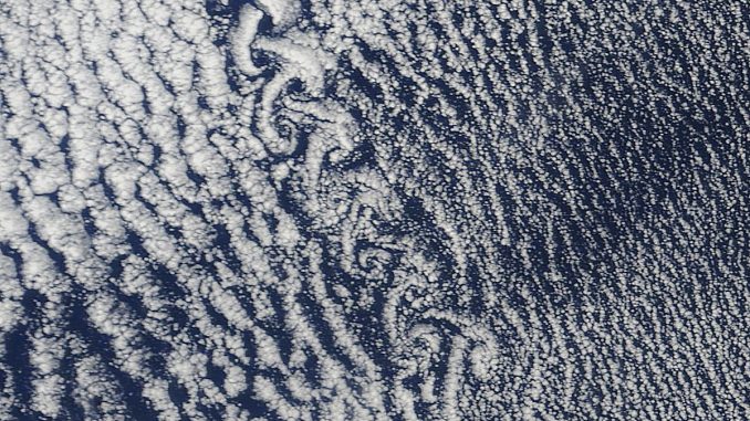 Scientific illustration: A satellite photo of clouds swirling into spirals.