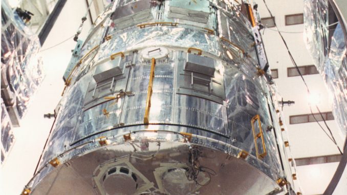 Scientific illustration of the Hubble Space Telescope being loaded into the gleaming VPF.