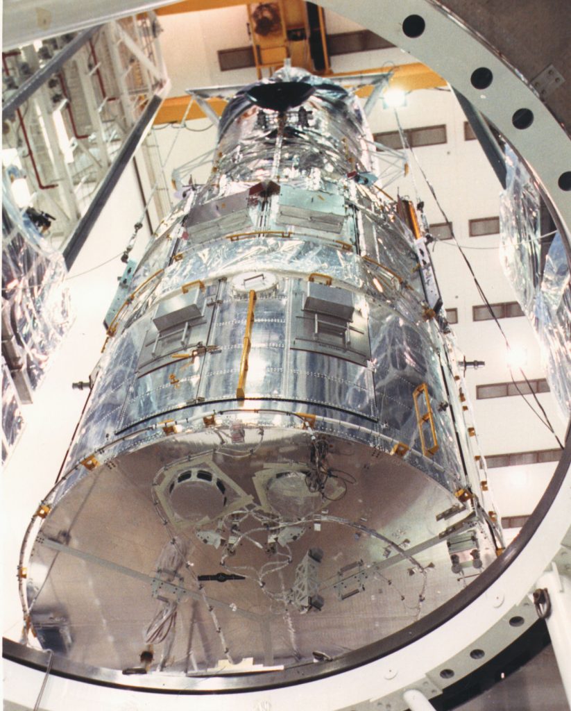 Scientific illustration of the Hubble Space Telescope being loaded into the gleaming VPF.