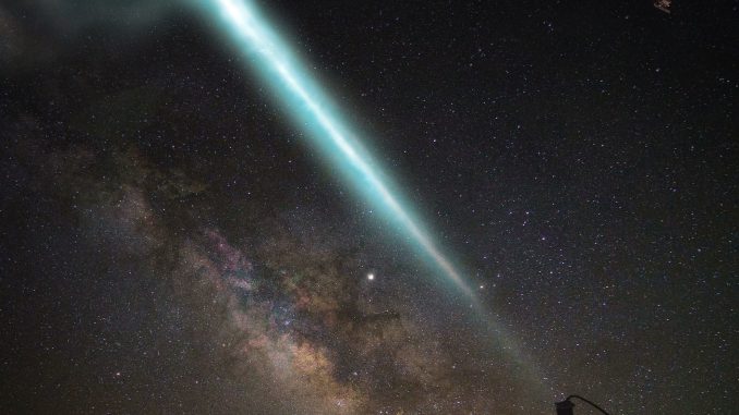Scientific illustration of a telescope array capturing a gamma-ray burst: dark skies and glowing energy fields. Superbossa.com and C. Righi.