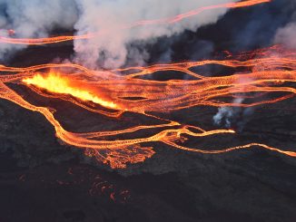 An aerial photo of flowing streams of lava, steam and smoke rising above the black stone and glowing orange lava. Photo from the USGS Hawaiian Volcano Observatory, taken by the Civil Air Patrol.
