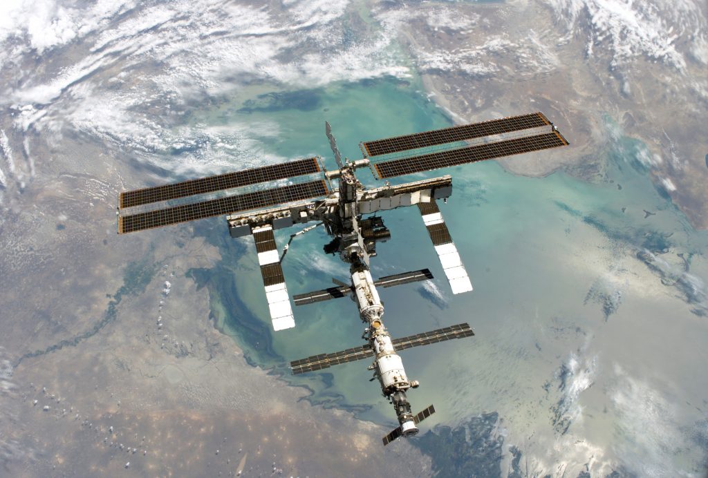Scientific illustration of the International Space Station, orbiting high above the Caspian Sea, as photographed by Space Shuttle Discovery.