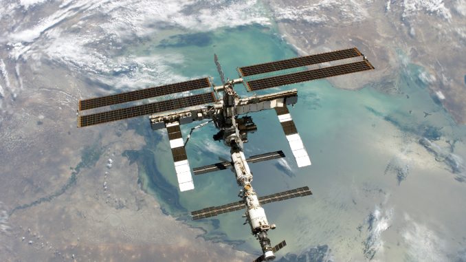 Scientific illustration of the International Space Station, orbiting high above the Caspian Sea, as photographed by Space Shuttle Discovery.