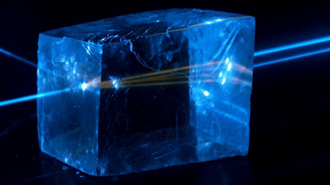 Scientific illustration by Jan Pavelka showing a blue laser creating a fluorescent glow inside a cube of calcite.