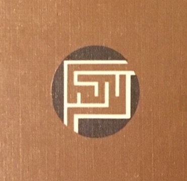 Scientific illustration of a human brain (or perhaps just a maze) as a very simplified informational icon in a 1960s visual style: brown background, black circle, a white bordered maze in brown forming a square inside the circle.