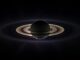 Scientific illustration of Saturn eclipsing the sun, a dramatic image of the ringed planet backlit in space.