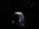 Scientific illustration of curved, glowing, colorful formations against the black backdrop of space - the curve of a galaxy like a horse's neck, a row of glowing spheres or discs like spinning Christmas lights, as photographed by the Webb Space Telescope.
