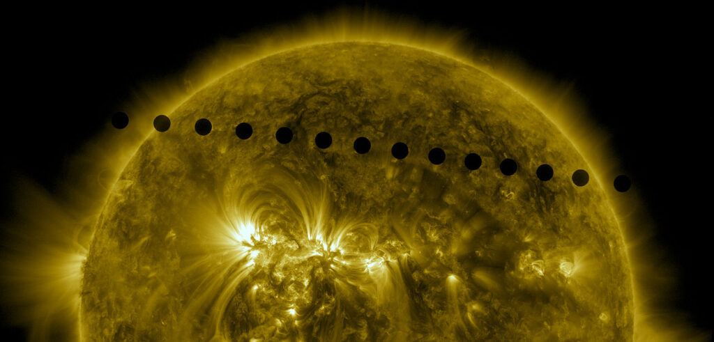 Scientific illustration of Venus transiting in front of the Sun, as captured by the Solar Dynamics Observetory satellite, a flaming metallic orb girdled by a series of perfectly circular silhouettes making a diagonal line from the upper left to the middle right of the image.
