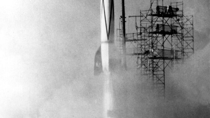 Scientific illustration of a rocket launching in the 1950s, metal scaffolding and exhaust clouds, a white tower rising skyward, gleaming in black and white.